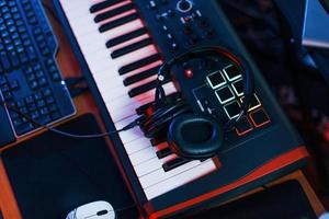 Close up view of headphones that lying down on the keyboard in the studio photo