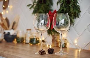 Glasses and x-mas decorations in the room. Bright garlands and lights photo