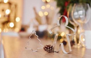 Glasses and x-mas decorations in the room. Bright garlands and lights photo