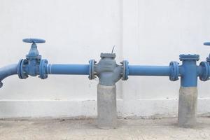 gran válvula de suministro de agua con un fondo blanco de la pared de cemento foto