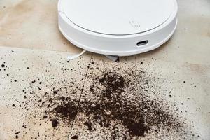 Robot vacuum cleaner cleans dirt on floor. Smart home concept photo