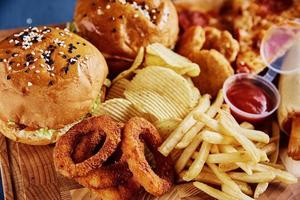 Unhealthy and junk food. Different types of fast food on the table, closeup photo