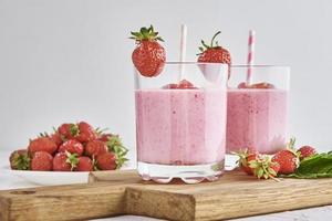 batido de fresa en vaso con paja y bayas frescas foto