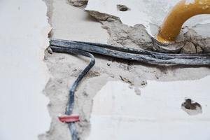 Old electrical cables in a brick wall. Danger wiring photo