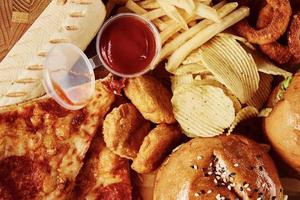 Unhealthy and junk food. Different types of fast food on the table, closeup photo