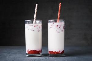 Two glasses with strawberry milk smoothie on a dark background photo