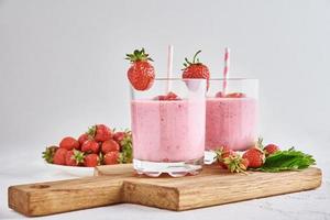 batido de fresa en vaso con paja y bayas frescas foto