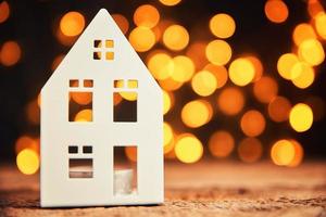 Toy house against blured bokeh lights background photo