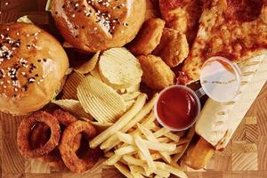 comida chatarra y poco saludable. diferentes tipos de comida rápida en la mesa, primer plano foto