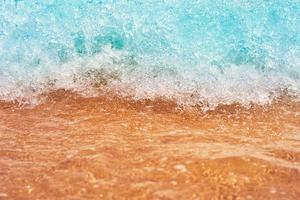 Sea wave on the sand beach, soft focus. Summer background photo