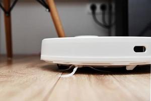 Robot vacuum cleaner working on the laminate floor. photo