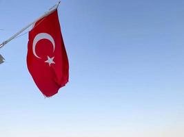 Large flag of Republic of Turkey on sky background photo