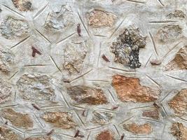 Background, texture, stone wall of round stones cobblestones bricks natural surface natural sharp convex rough stone cobblestone with cracks photo