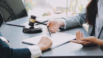 Justice and law concept.Male judge in a courtroom with the gavel, working with, computer and docking keyboard, eyeglasses, on table in morning light video