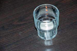 A burning scented candle on a wooden table to create a relaxing atmosphere during dinner. photo