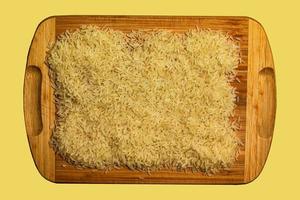 Background of long grain parboiled uncooked rice. Rice groats as background and texture. photo