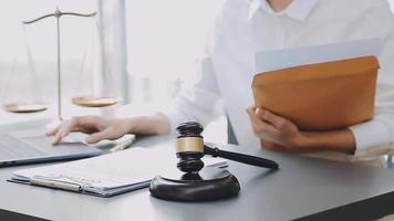 Justice and law concept.Male judge in a courtroom with the gavel, working with, computer and docking keyboard, eyeglasses, on table in morning light video