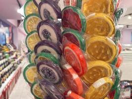 piruletas envueltas de colores en exhibición, dulces hechos a mano, piruletas pequeñas y grandes. foto