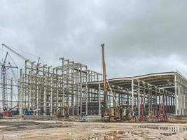 construction of a new complex at the plant. metal structures for the construction of the foundation. yellow crane carries heavy material through the air photo