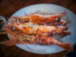 Blur or defocused photo of three freshly cooked honey grilled prawns