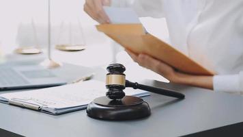 Justice and law concept.Male judge in a courtroom with the gavel, working with, computer and docking keyboard, eyeglasses, on table in morning light video