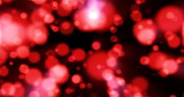 Beautiful festive bokeh effect, red love circles of light shining falling falling glowing christmas new year on black background. Abstract background. Screensaver photo