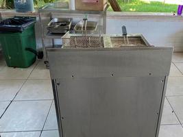 Metal deep fryer for cooking deep-fried french fries in the kitchen in a fast food restaurant photo