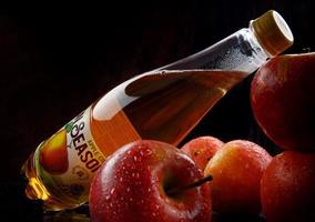 KRASNOYARSK, RUSSIA - JUNE 09, 2022 A bottle of Bon Season cider in close-up and red apples. photo