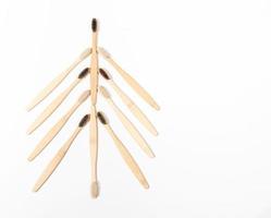 cepillos de dientes de bambú ecológicos para el cuidado dental, la higiene personal, dispuestos como un árbol de navidad en blanco. vista superior. foto