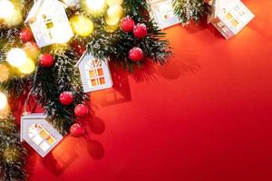 Diagonal composition of xmas tree branches, Christmas lights white lodges, berries, bokeh lights on red with shadows. photo