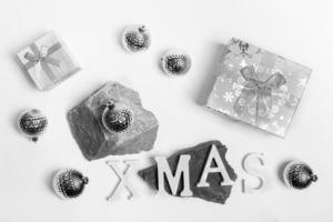 Christmas trendy monochrome arrangement of Xmas silver and white decorations on stone stands and on on white. Top view. photo