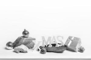 Christmas trendy creative minimal monochrome composition. Xmas decorations on stone stands on white with copy space. photo