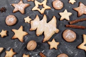 Arrangement of homemade Christmas cookies, cinnamon, walnuts, anise stars on black close up. photo
