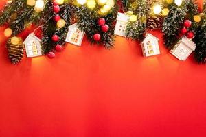 Xmas tree branches, luminous Christmas lights white lodges, red berries and sparkle bokeh lights on red with copy space. photo