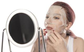 Cosmetic procedure. Woman's face with white cosmetic mask photo