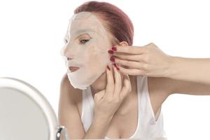 procedimiento cosmético. cara de mujer con máscara cosmética blanca foto