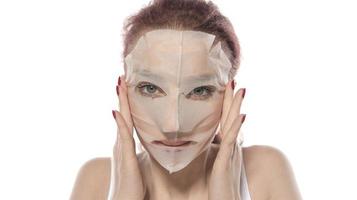 Cosmetic procedure. Woman's face with white cosmetic mask photo
