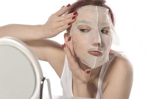 Cosmetic procedure. Woman's face with white cosmetic mask photo