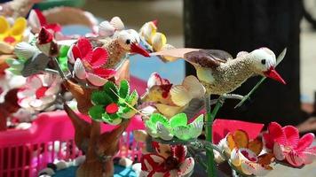 souvenirs de plage, oiseaux miniatures artisanaux et fleurs faites de coquillages peints de couleurs vives. video