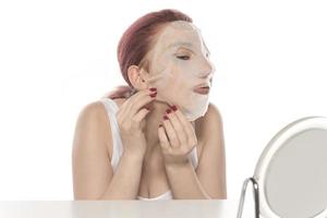 Cosmetic procedure. Woman's face with white cosmetic mask photo