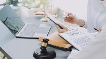 Justice and law concept.Male judge in a courtroom with the gavel, working with, computer and docking keyboard, eyeglasses, on table in morning light video