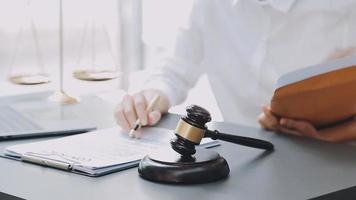 Justice and law concept.Male judge in a courtroom with the gavel, working with, computer and docking keyboard, eyeglasses, on table in morning light video
