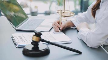 Justice and law concept.Male judge in a courtroom with the gavel, working with, computer and docking keyboard, eyeglasses, on table in morning light video