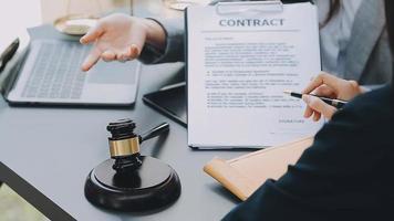 Justice and law concept.Male judge in a courtroom with the gavel, working with, computer and docking keyboard, eyeglasses, on table in morning light video