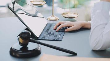 Justice and law concept.Male judge in a courtroom with the gavel, working with, computer and docking keyboard, eyeglasses, on table in morning light video