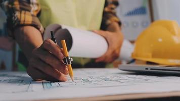 ingénieur en construction travaillant au plan directeur pour construire de grands bâtiments commerciaux au bureau. outils d'ingénierie et concept de construction. video