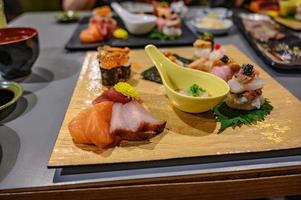 Set of sushi and sashimi on the wooden plate in japanese restaurant. photo