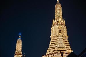 wat arun con la azotea del edificio en la noche. wat arun ratchawararam ratchawaramahawihan o wat arun es un templo budista en el distrito de bangkok yai de bangkok foto