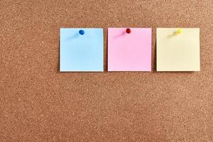 Three sticky notes pinned on a cork board. Planning and brainstorming concept photo