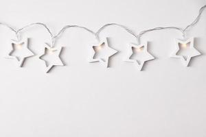 Garland made of wooden stars on white background photo